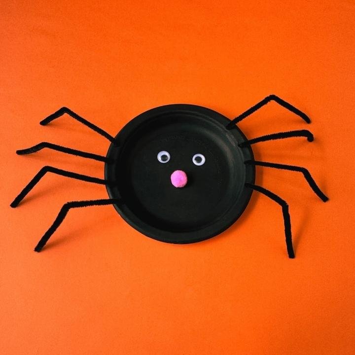 Fun preschool paper plate spider craft for Halloween, made with googly eyes and pipe cleaner legs.