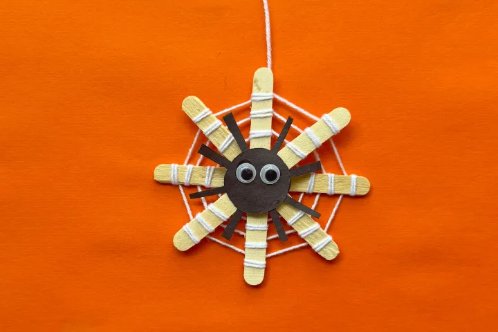 This DIY popsicle stick spider web craft is a fun preschool Halloween crat for kids. Made using 3 simple supplies, perfect for Halloween spider activities.