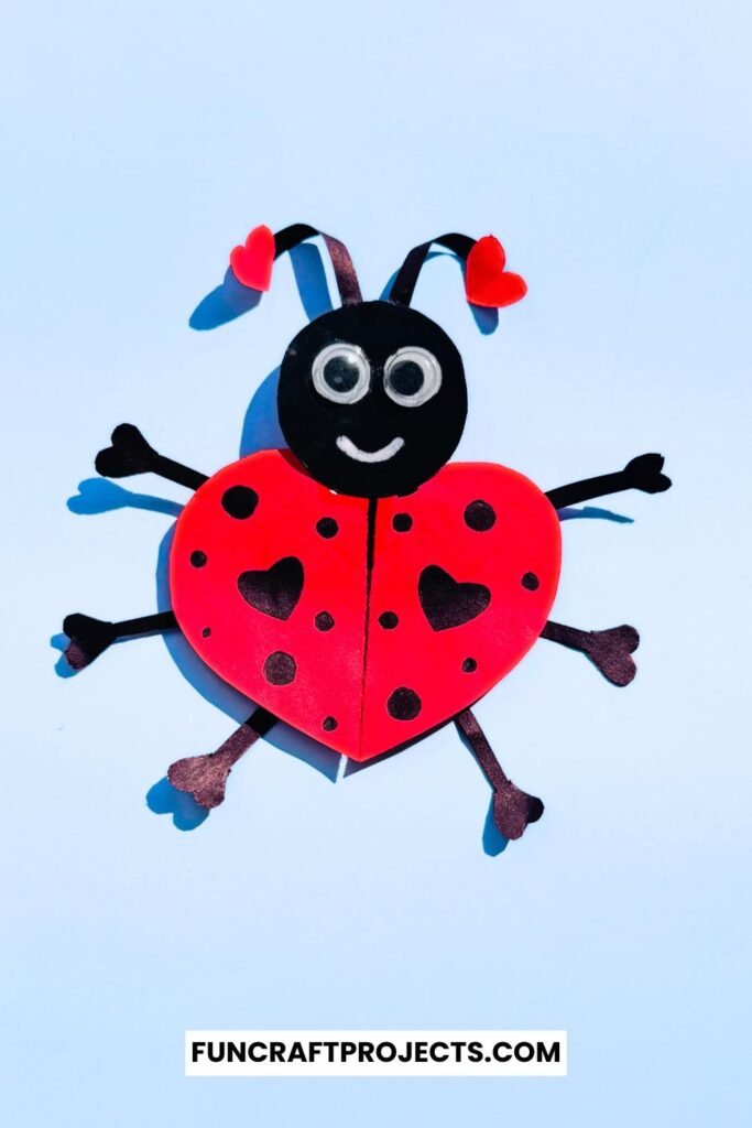 Heart Shaped Ladybug Craft made with red and black construction paper, googly eyes, and heart-shaped wings is a fun Valentine’s Day craft for kids.