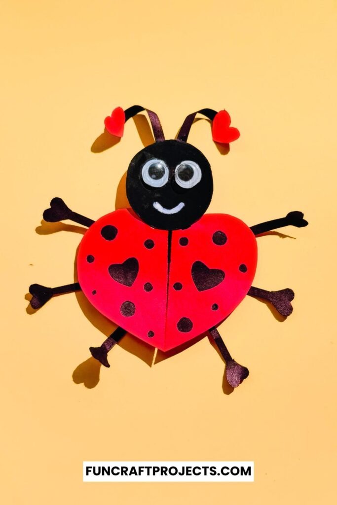 Heart Shaped Ladybug Craft made with red and black construction paper, googly eyes, and heart-shaped wings is a fun Valentine’s Day craft for kids.