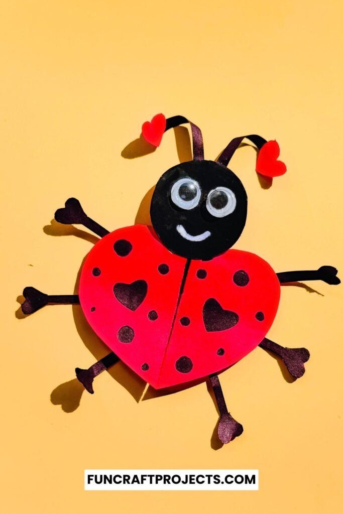 Heart Shaped Ladybug Craft made with red and black construction paper, googly eyes, and heart-shaped wings is a fun Valentine’s Day craft for kids.