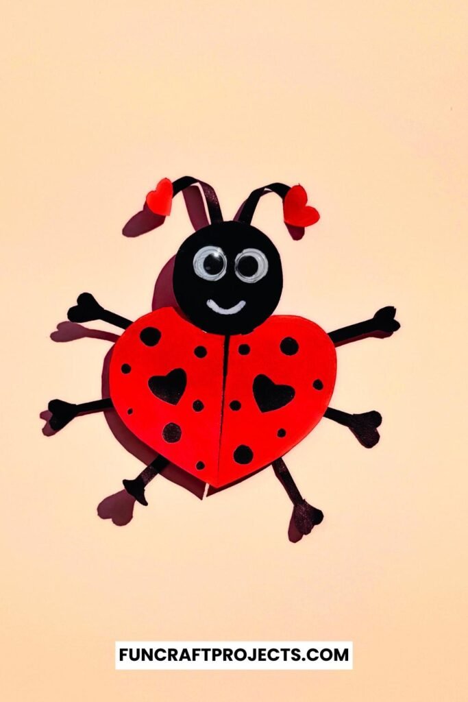 Heart Shaped Ladybug Craft made with red and black construction paper, googly eyes, and heart-shaped wings is a fun Valentine’s Day craft for kids.