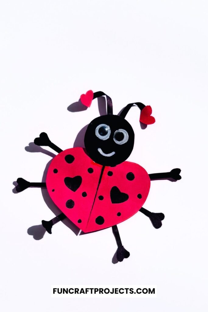 Heart Shaped Ladybug Craft made with red and black construction paper, googly eyes, and heart-shaped wings is a fun Valentine’s Day craft for kids.