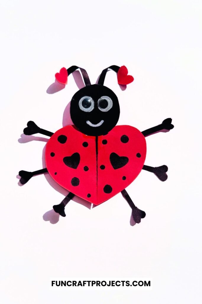 Heart Shaped Ladybug Craft made with red and black construction paper, googly eyes, and heart-shaped wings is a fun Valentine’s Day craft for kids.