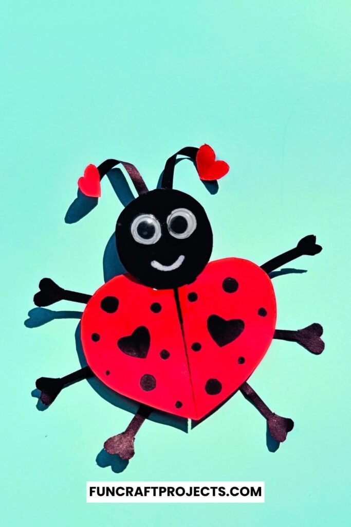 Heart Shaped Ladybug Craft made with red and black construction paper, googly eyes, and heart-shaped wings is a fun Valentine’s Day craft for kids.