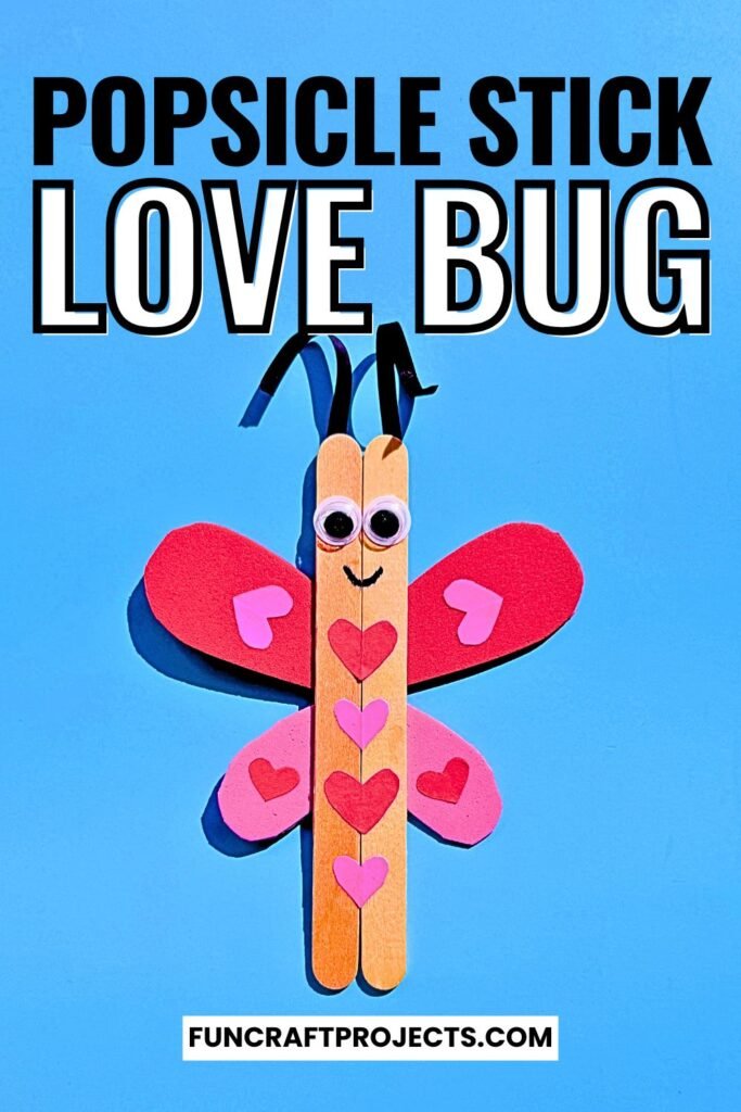 A cute Popsicle Stick Love Bug Craft made with wooden craft sticks, red and pink heart-shaped wings, and googly eyes, displayed on a blue background.