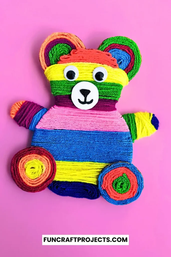 Yarn Wrapped Teddy Bear Craft with rainbow-colored yarn, googly eyes, and a cute face made from craft foam. A fun and creative craft for kids