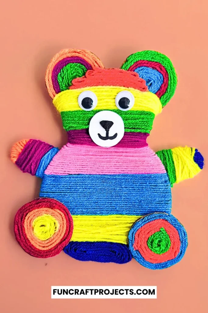 Yarn Wrapped Teddy Bear Craft with rainbow-colored yarn, googly eyes, and a cute face made from craft foam. A fun and creative craft for kids