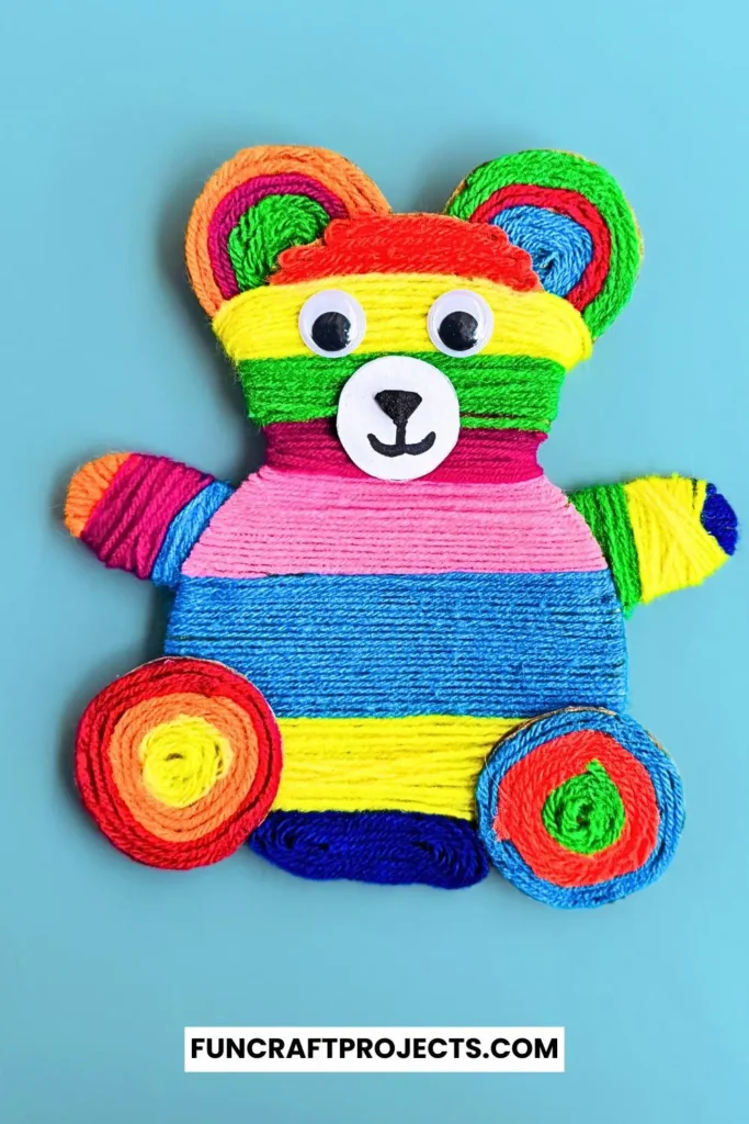 Yarn Wrapped Teddy Bear Craft with rainbow-colored yarn, googly eyes, and a cute face made from craft foam. A fun and creative craft for kids