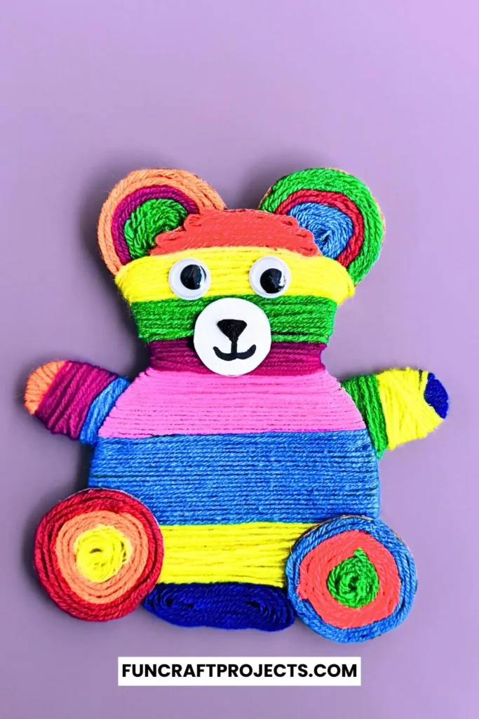 Yarn Wrapped Teddy Bear Craft with rainbow-colored yarn, googly eyes, and a cute face made from craft foam. A fun and creative craft for kids