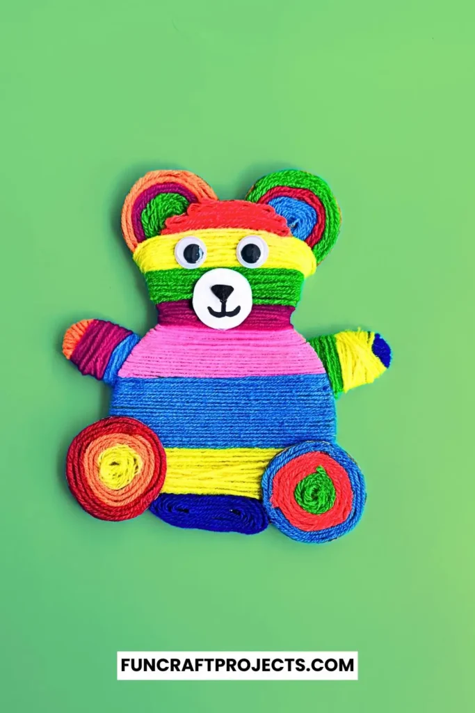 Yarn Wrapped Teddy Bear Craft with rainbow-colored yarn, googly eyes, and a cute face made from craft foam. A fun and creative craft for kids