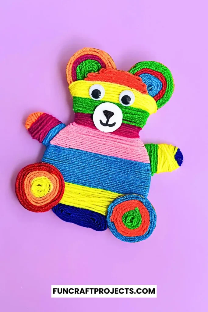 Yarn Wrapped Teddy Bear Craft with rainbow-colored yarn, googly eyes, and a cute face made from craft foam. A fun and creative craft for kids