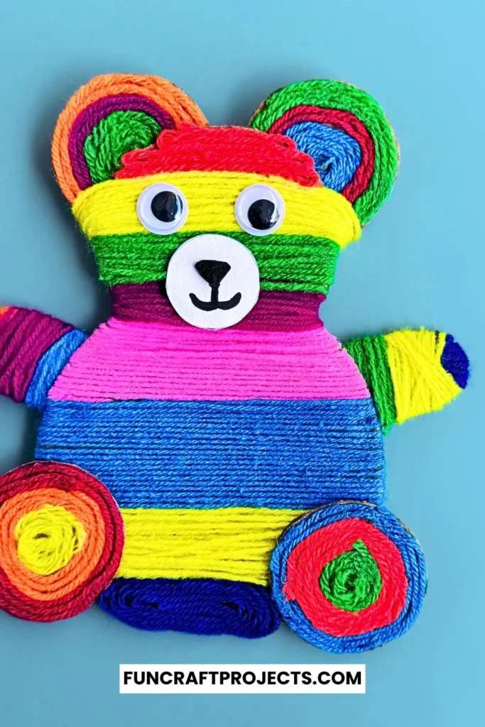 Yarn Wrapped Teddy Bear Craft with rainbow-colored yarn, googly eyes, and a cute face made from craft foam. A fun and creative craft for kids