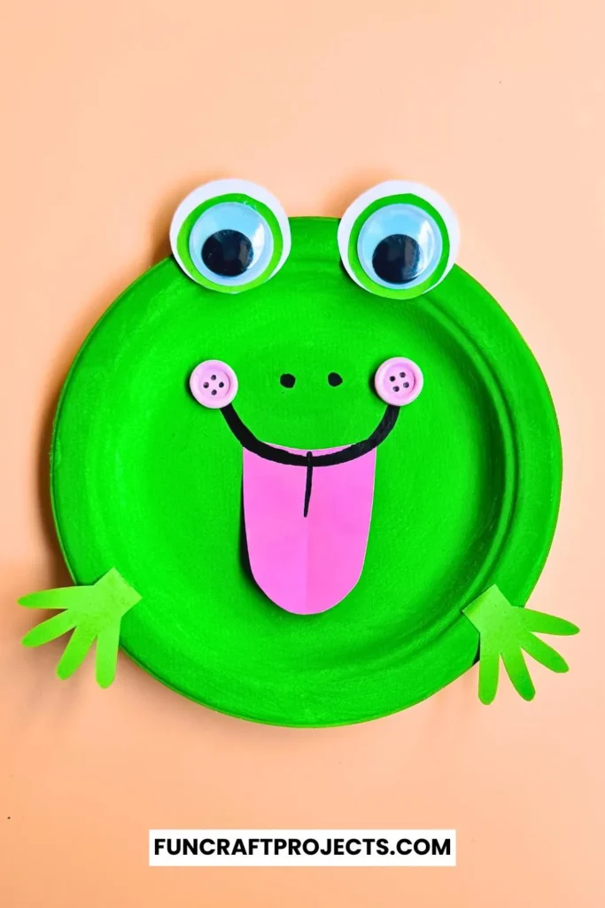 Paper Plate Frog Craft – A bright green paper plate frog with big googly eyes, a pink tongue, and cut-out hands, perfect for preschool crafts and fun activities