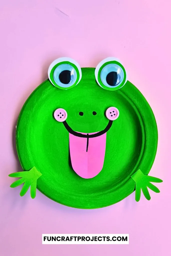 Paper Plate Frog Craft – A bright green paper plate frog with big googly eyes, a pink tongue, and cut-out hands, perfect for preschool crafts and fun activities