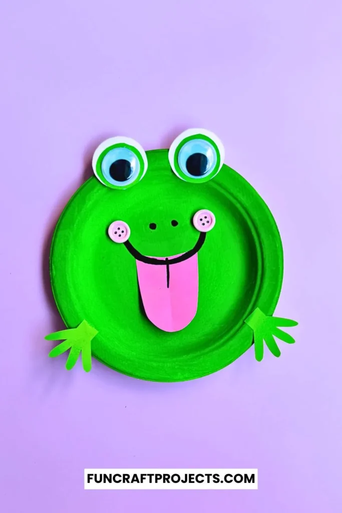 Paper Plate Frog Craft – A bright green paper plate frog with big googly eyes, a pink tongue, and cut-out hands, perfect for preschool crafts and fun activities