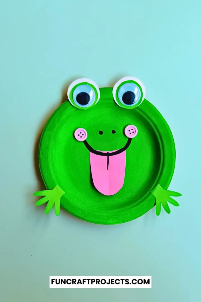 Paper Plate Frog Craft – A bright green paper plate frog with big googly eyes, a pink tongue, and cut-out hands, perfect for preschool crafts and fun activities