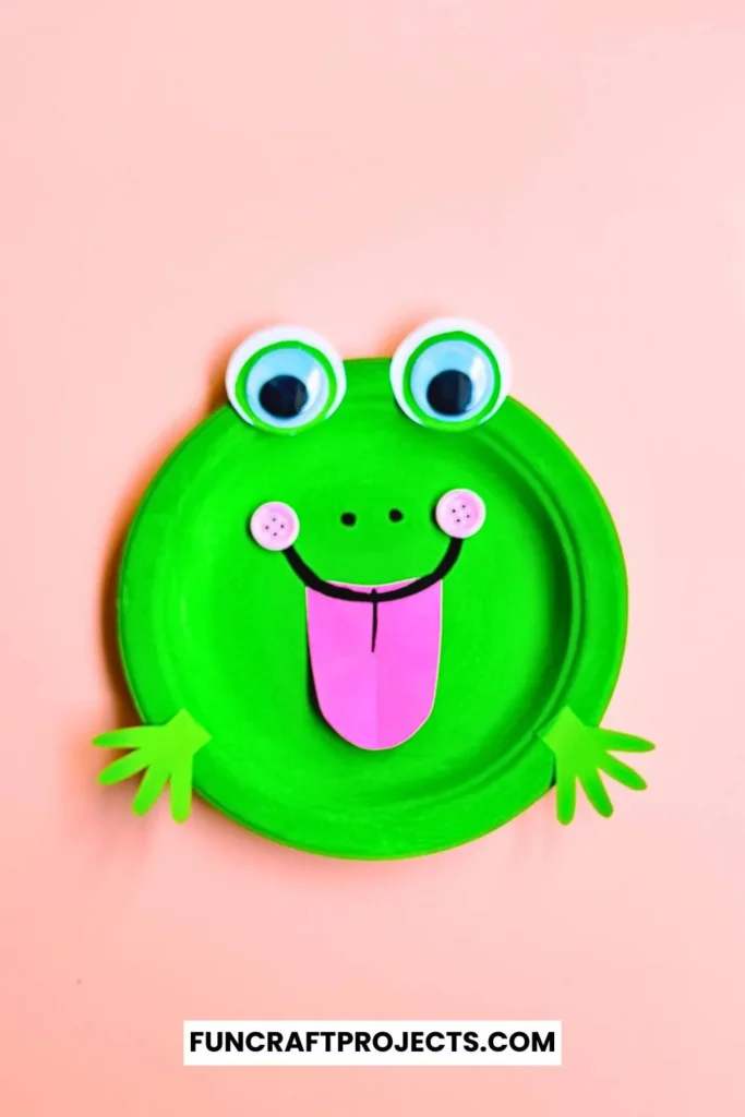 Paper Plate Frog Craft – A bright green paper plate frog with big googly eyes, a pink tongue, and cut-out hands, perfect for preschool crafts and fun activities