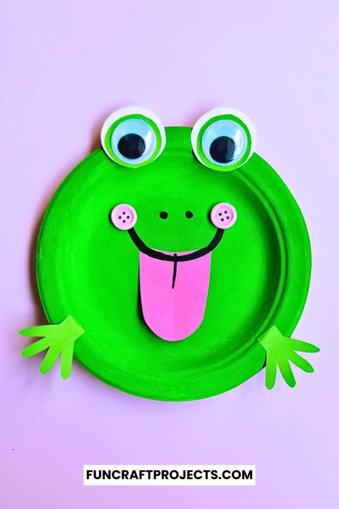 Paper Plate Frog Craft – A bright green paper plate frog with big googly eyes, a pink tongue, and cut-out hands, perfect for preschool crafts and fun activities